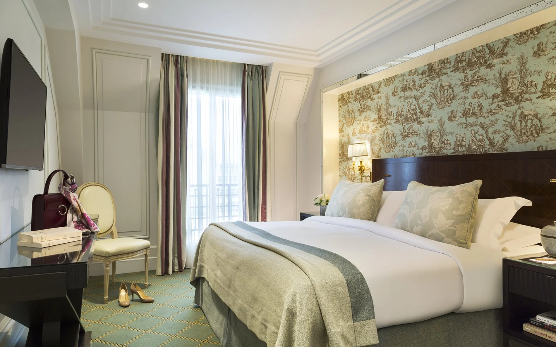 Grand lit double et décoration élégante dans la Terrace Junior Suite de l’Hôtel San Régis à Paris.